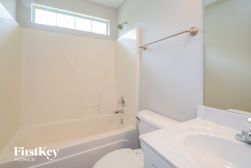 a white bathroom with a tub and a sink and a toilet