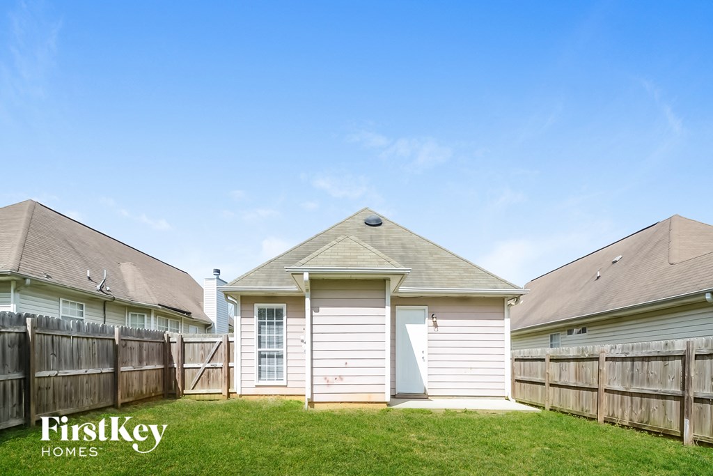 the backyard of a house with a yard and a fence