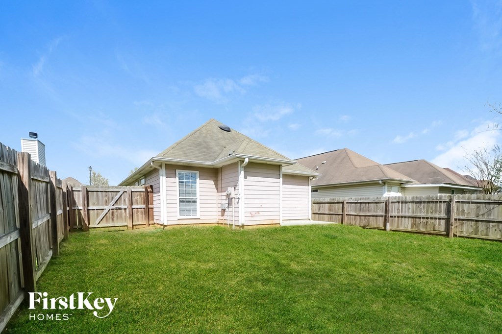 the backyard of a house with a yard and a fence