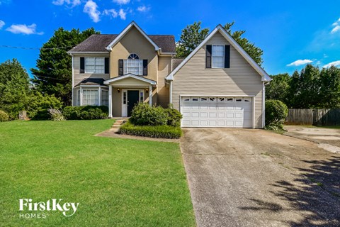 a house with a white garage door on a green lawn