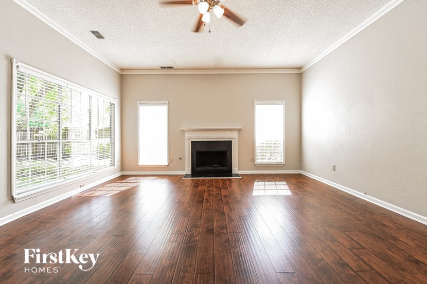 an empty living room with wood floors and a fireplace