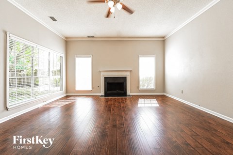 an empty living room with wood floors and a fireplace