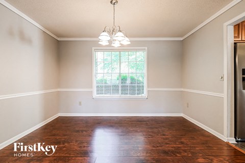 a empty dining room with wood floors and a window