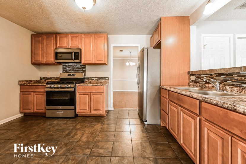 a kitchen with wooden cabinets and stainless steel appliances