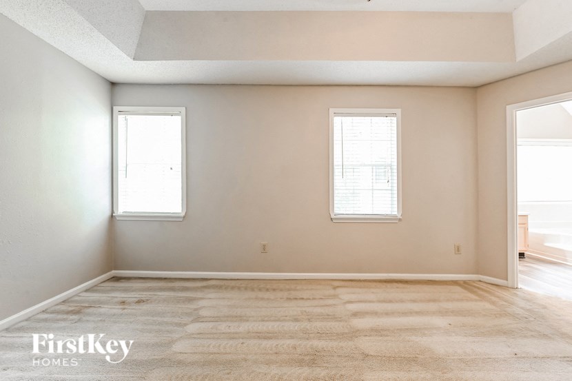 the living room of an empty house with two windows