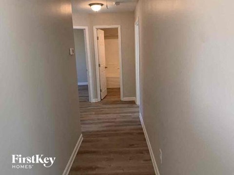 a hallway with white walls and a wooden floor
