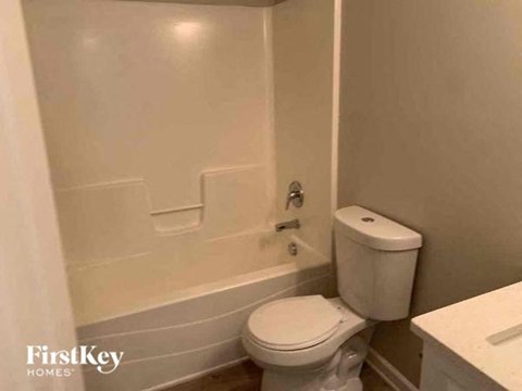 a bathroom with a toilet and a bath tub