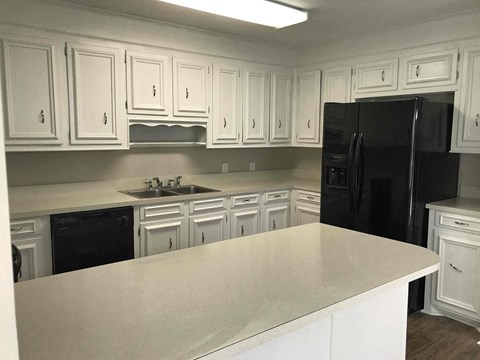 a kitchen with white cabinets and black appliances
