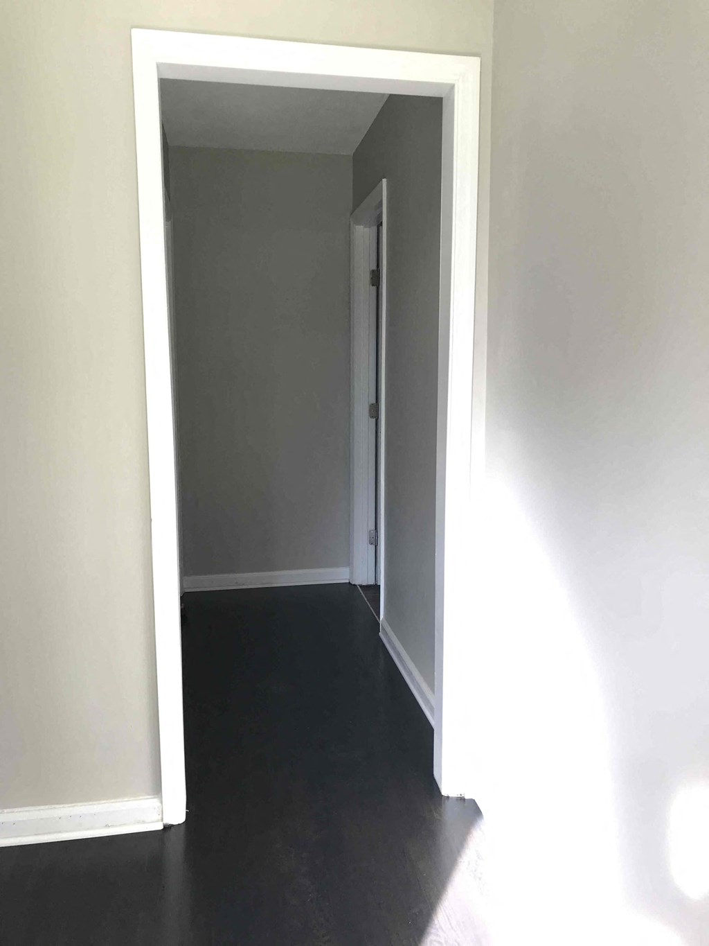 an empty room with a door open to a hallway