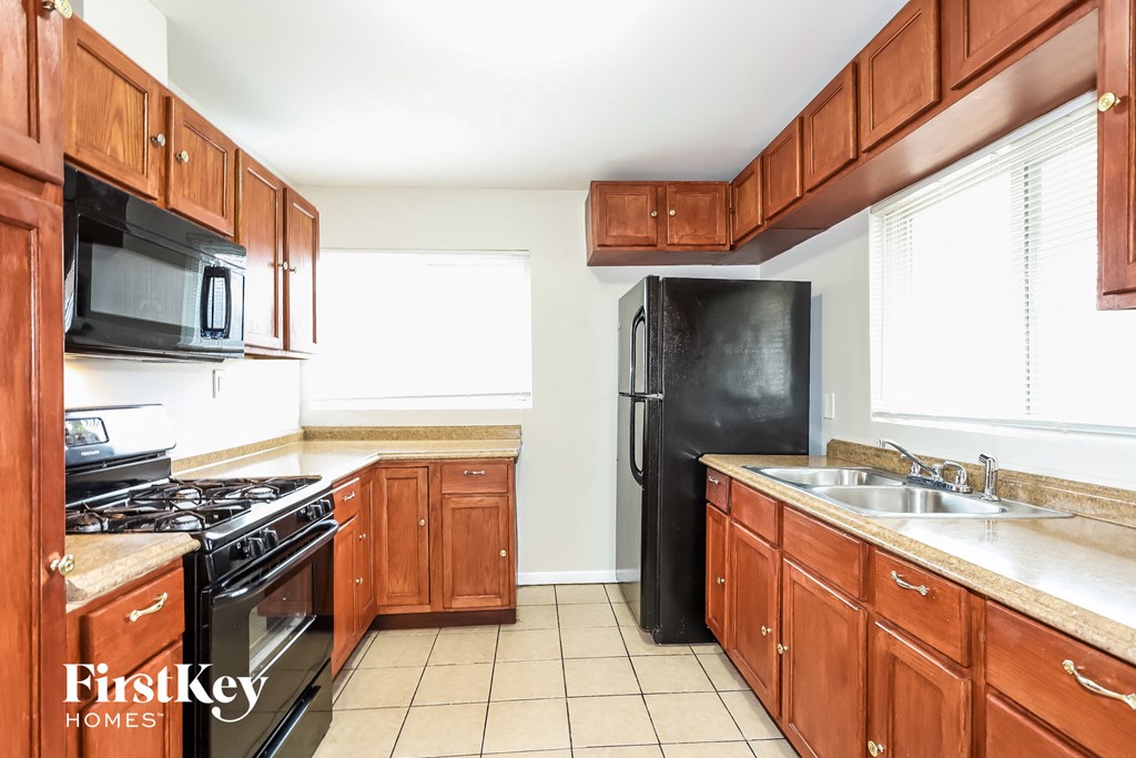 A kitchen with wooden cabinets and black appliances.