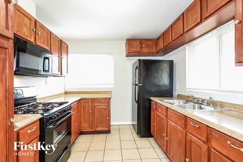 A kitchen with wooden cabinets and black appliances.