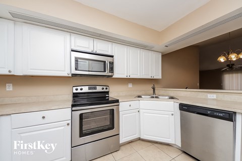 A kitchen with white cabinets and stainless steel appliances.