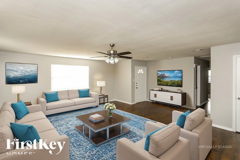 A living room with a couch, chairs, and a coffee table.