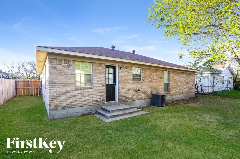 A small house with a brick exterior and a black door is for sale.