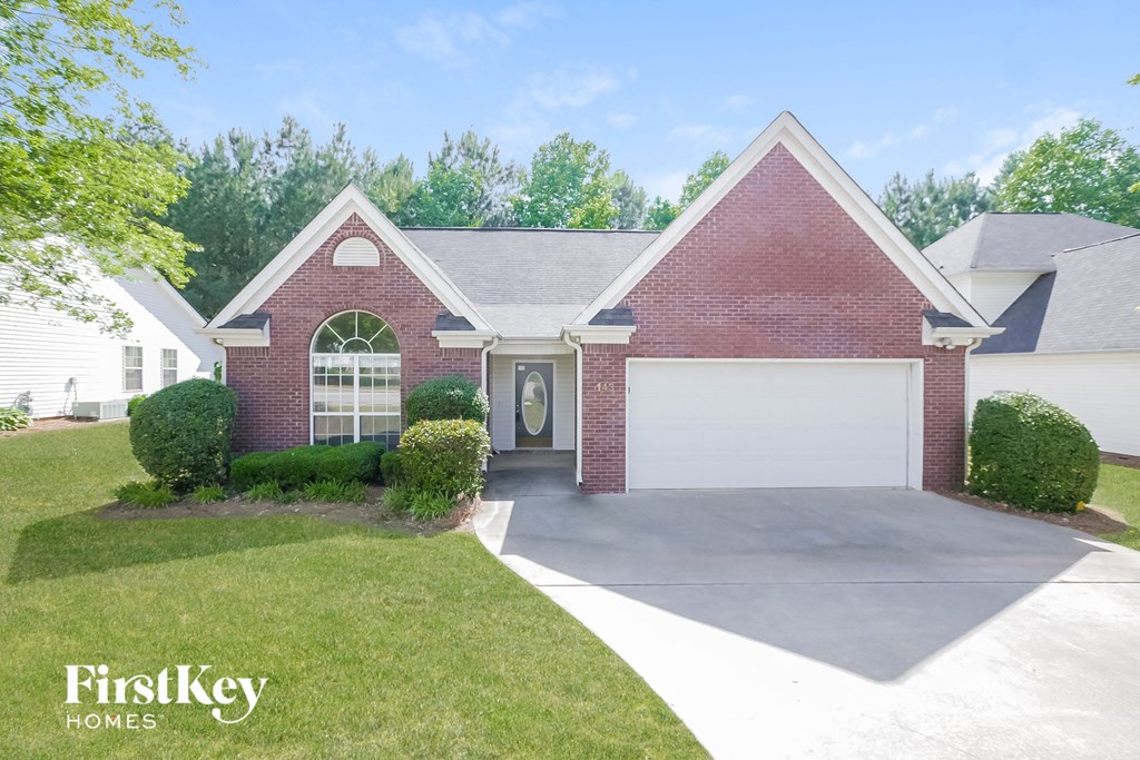 a red brick home with a white garage door and a driveway