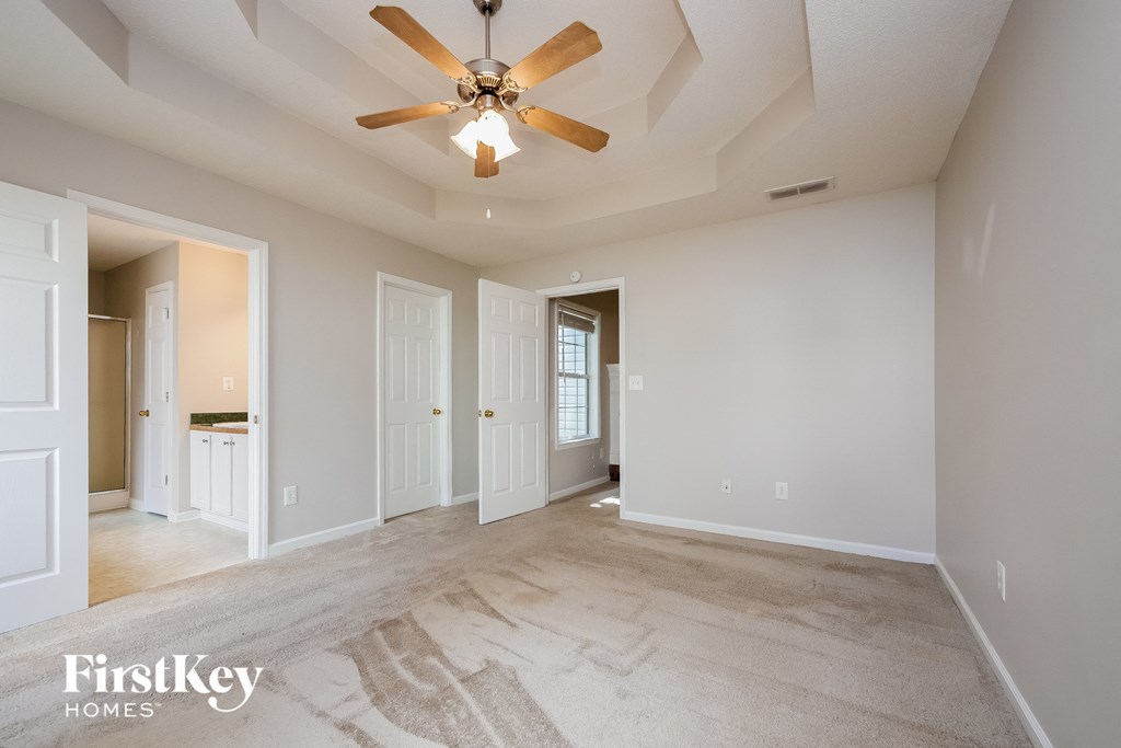 an empty living room with a ceiling fan