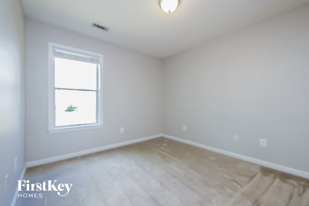 a room with white walls and a window and wooden floors