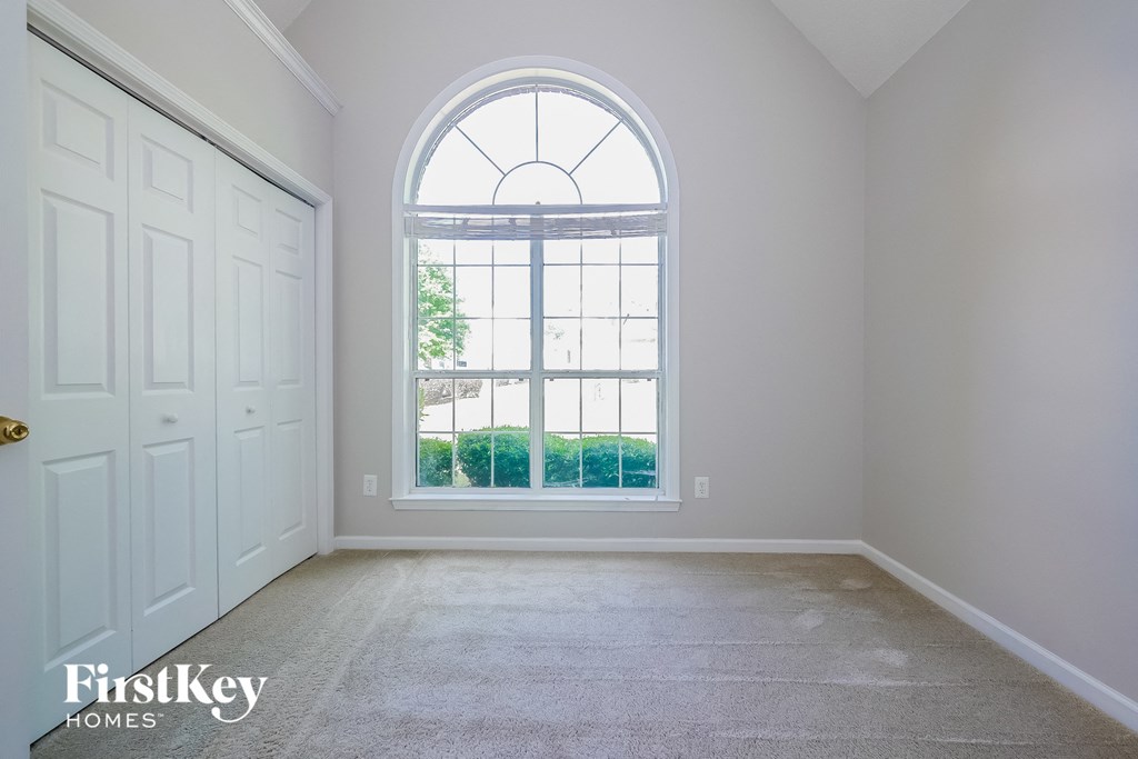 an empty living room with a large arched window