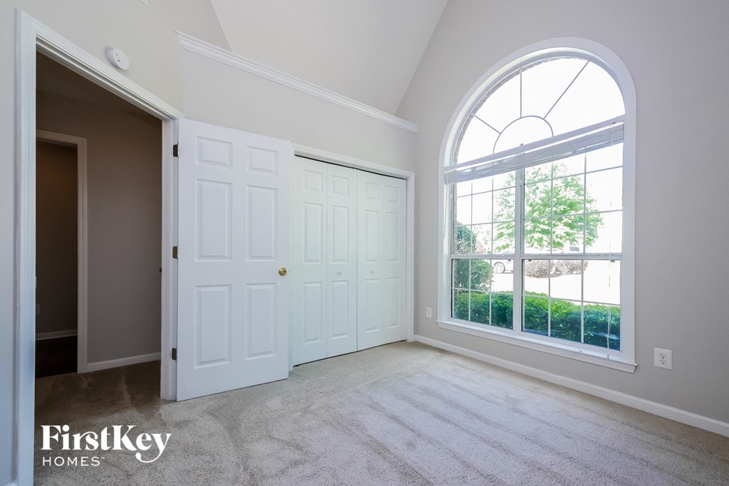an empty living room with a large window and white doors