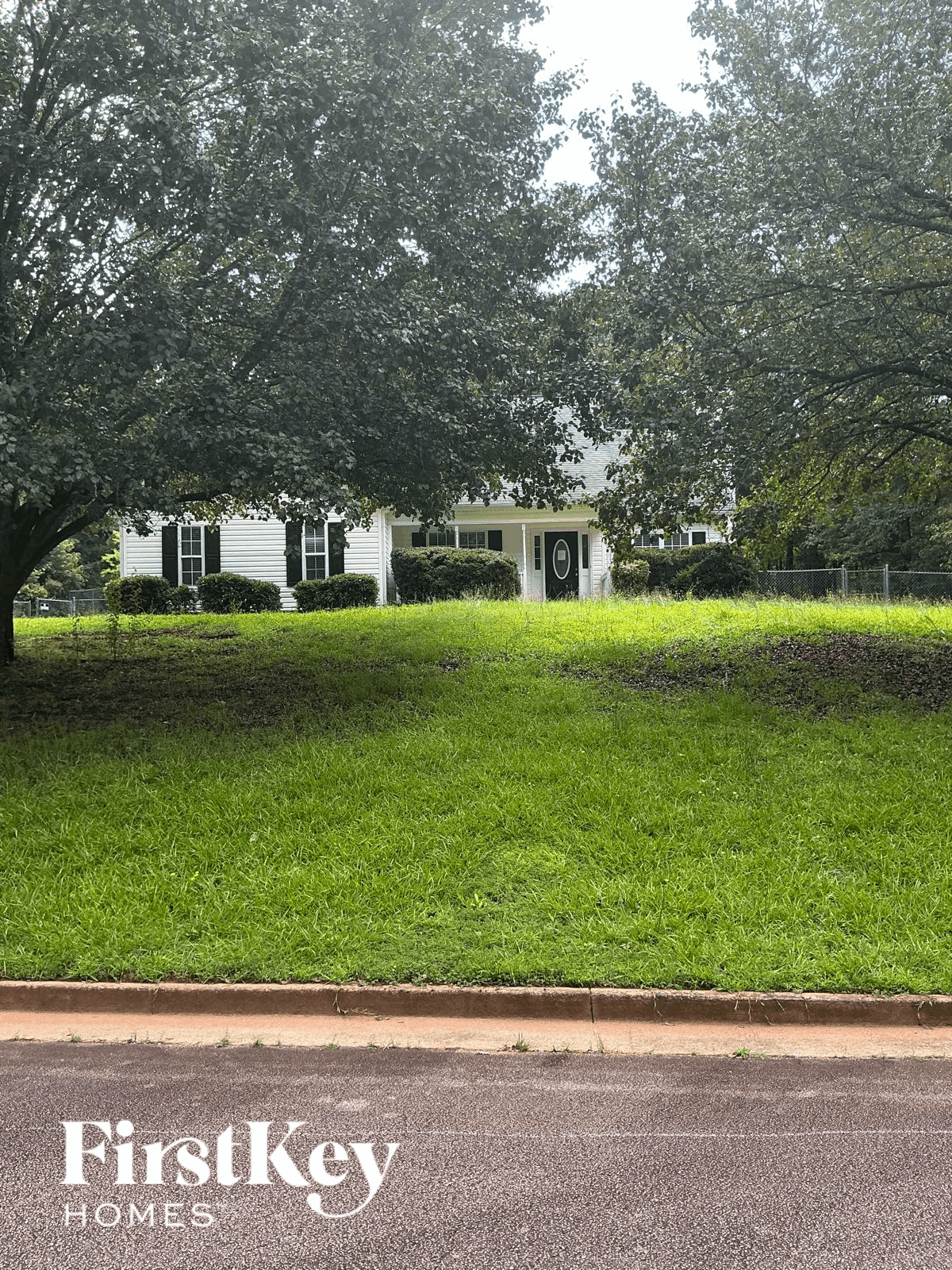 A white house with a green lawn in front of it.