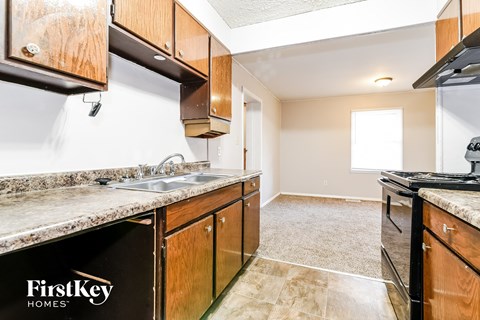 A kitchen with a sink and a stove top oven.