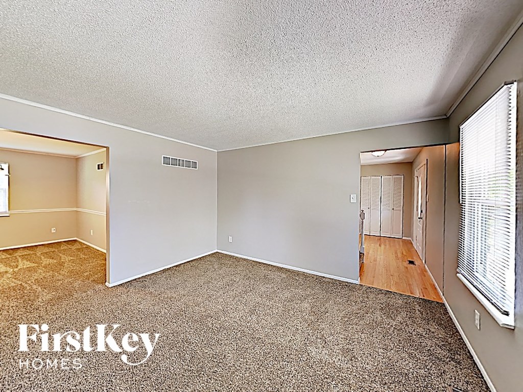 the living room of an empty house with a large window
