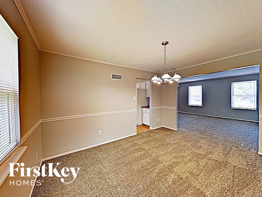 the living room and dining room of an empty house
