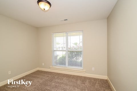 the living room of a new home with a large window and carpet