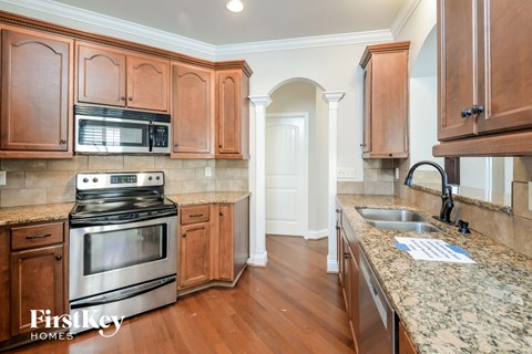 a kitchen with wooden cabinets and stainless steel appliances and granite counter tops