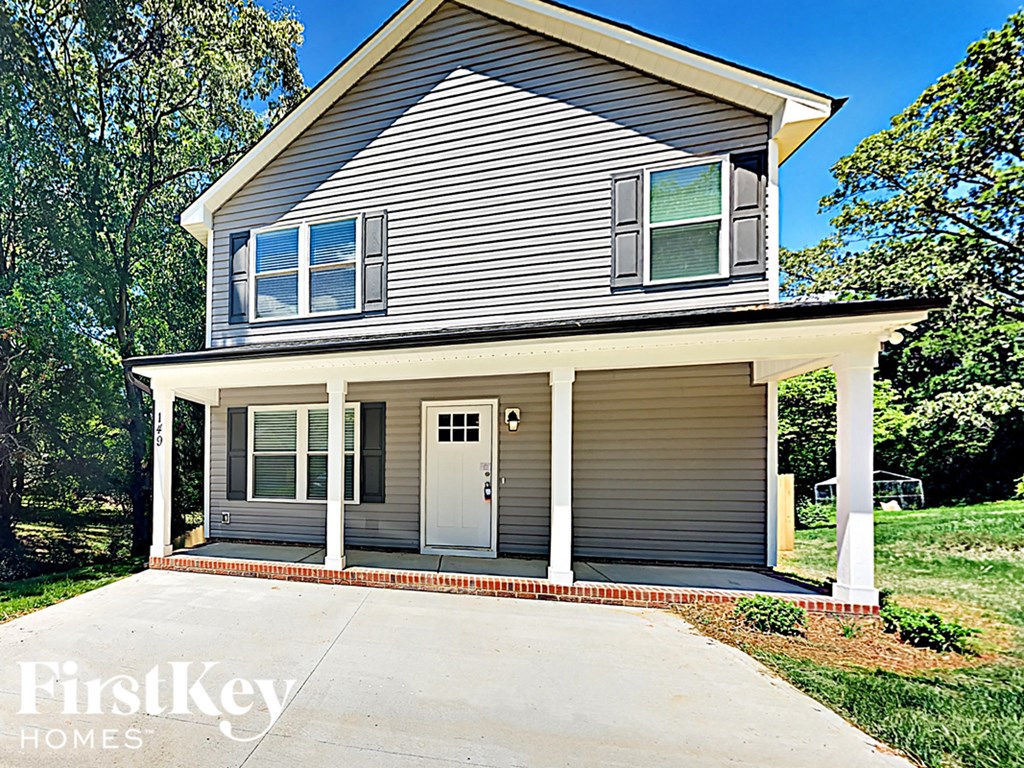 A house with a grey siding and a white door is for sale by FirstKey Homes.