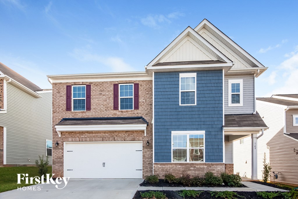 a blue and brick house with a white garage door