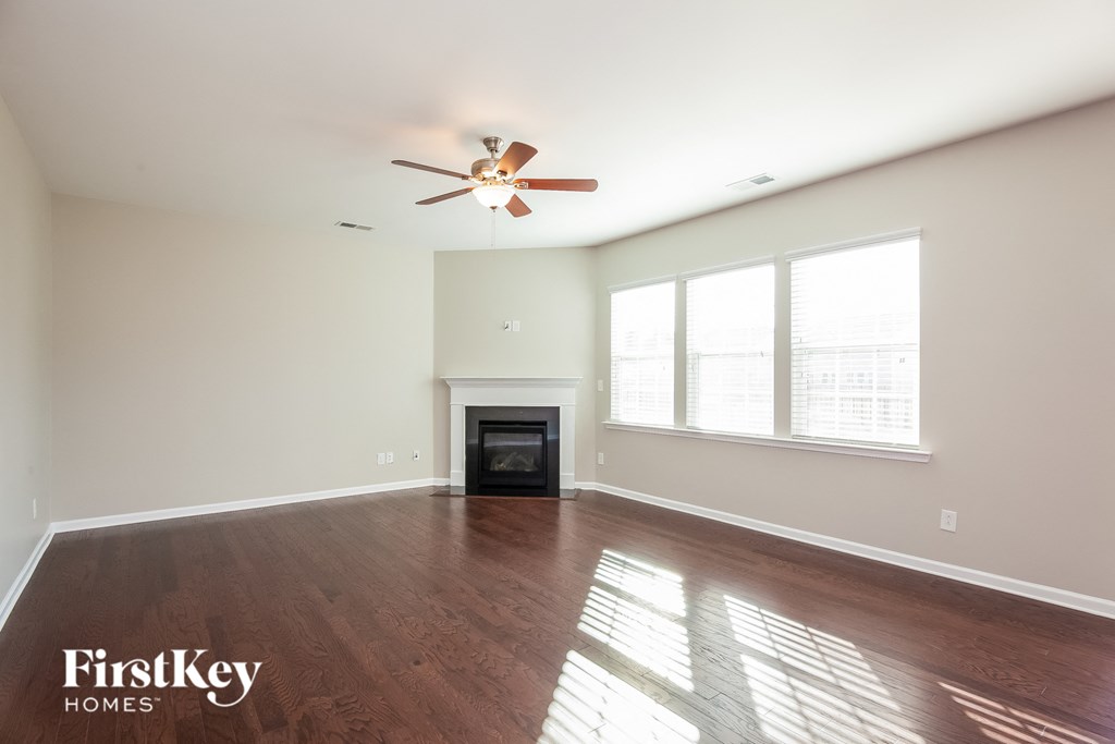 a living room with a fireplace and a ceiling fan