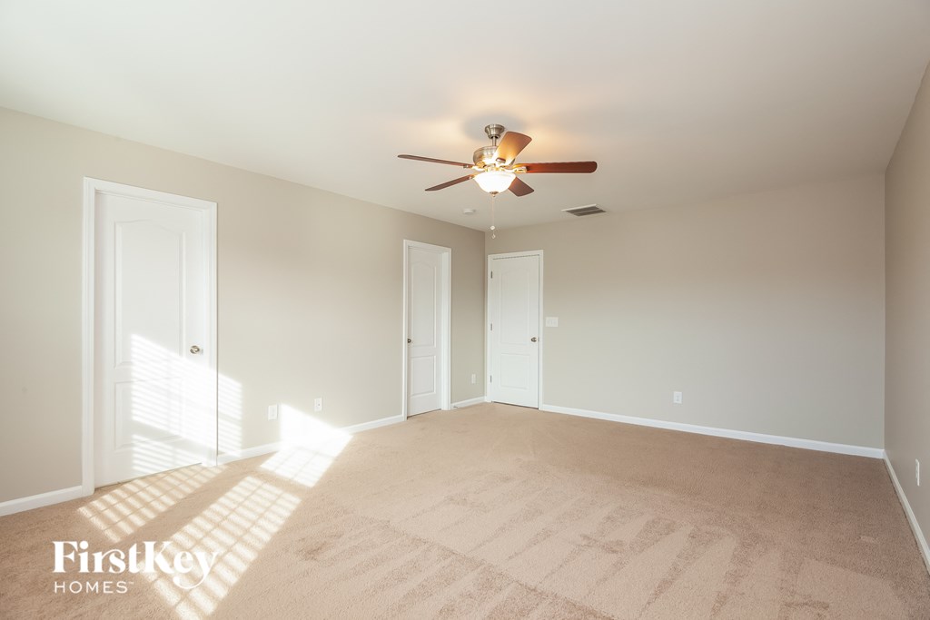 a empty living room with a ceiling fan