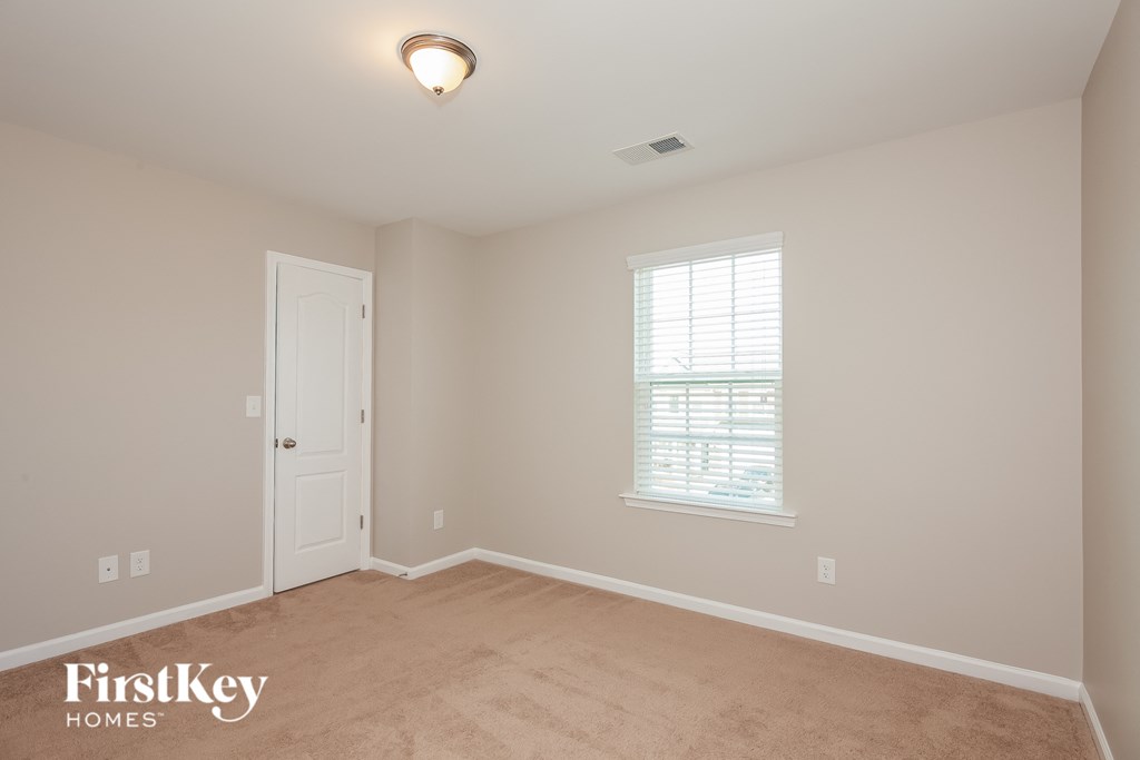 a bedroom with a carpeted floor and a white door
