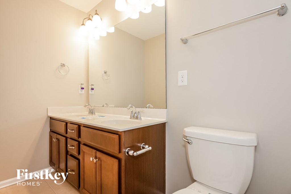 a bathroom with a toilet and a sink and a mirror