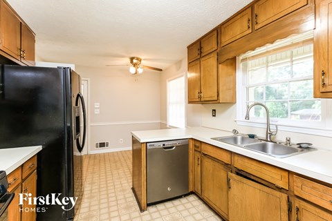 a kitchen with wooden cabinets and a sink and a refrigerator