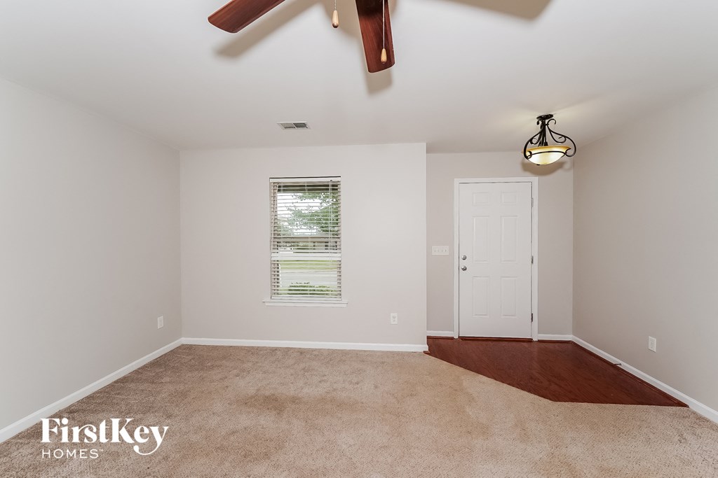 A room with a ceiling fan and a window with blinds.