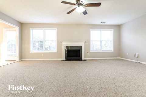 a living room with a fireplace and a ceiling fan