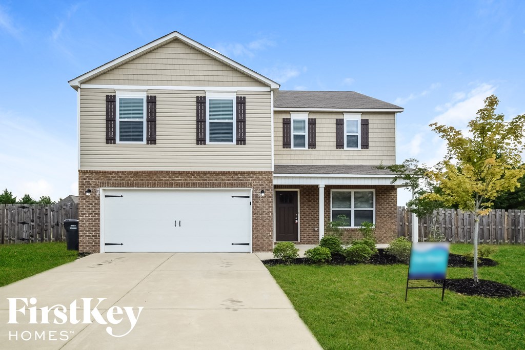 a tan house with a white garage door and a blue chair in front of it
