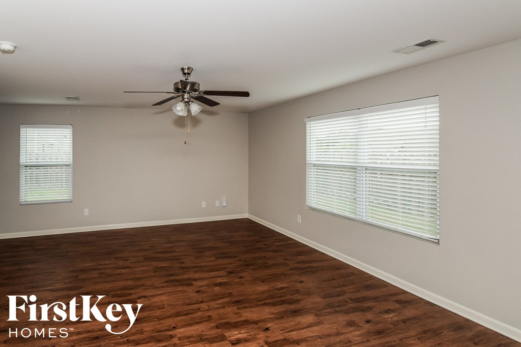 a living room with wood floors and a ceiling fan