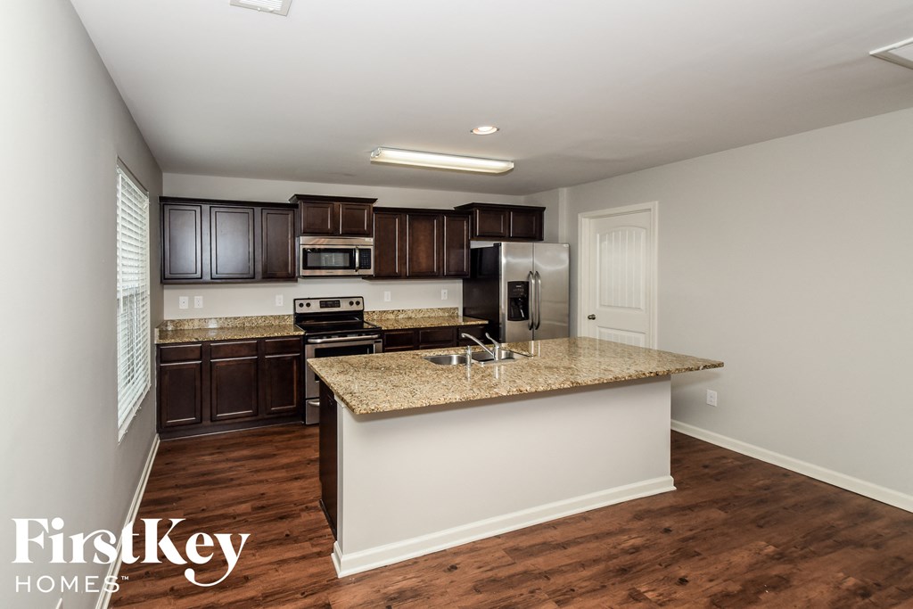 a kitchen with brown cabinets and a granite counter top
