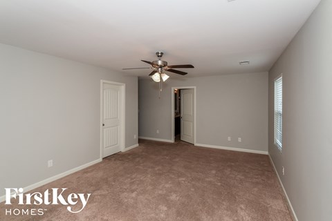a living room with carpet and a ceiling fan