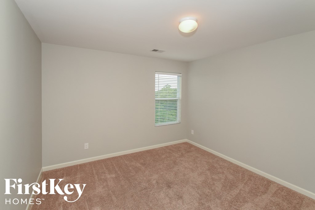 a bedroom with a carpeted floor and a window