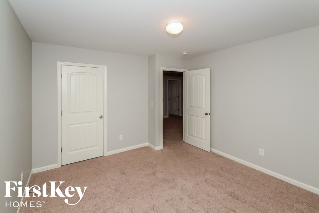 a bedroom with two closets and a carpeted floor and two doors