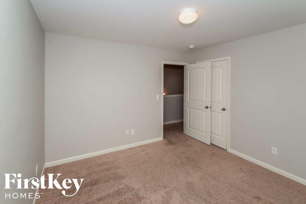 a bedroom with a carpeted floor and a door to a closet