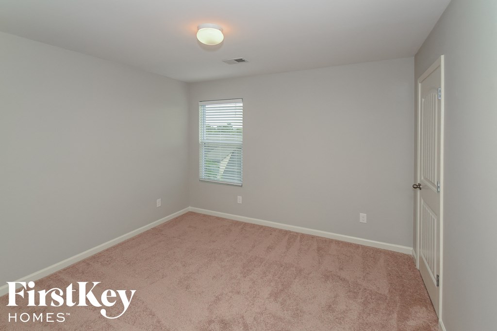 a bedroom with a carpeted floor and a white door