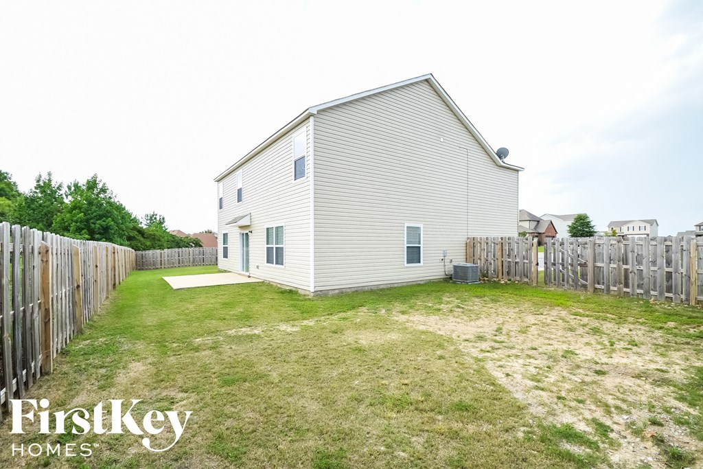 the backyard of a house with a yard and a fence