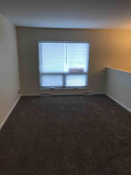 an empty room with a window and a carpet