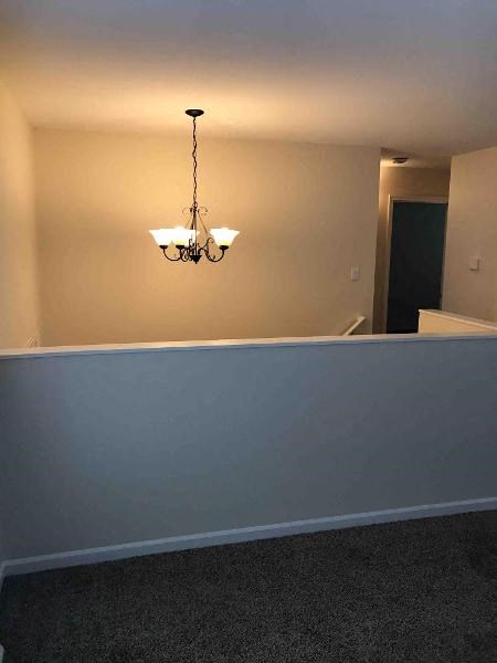 an empty room with a chandelier and a blue wall