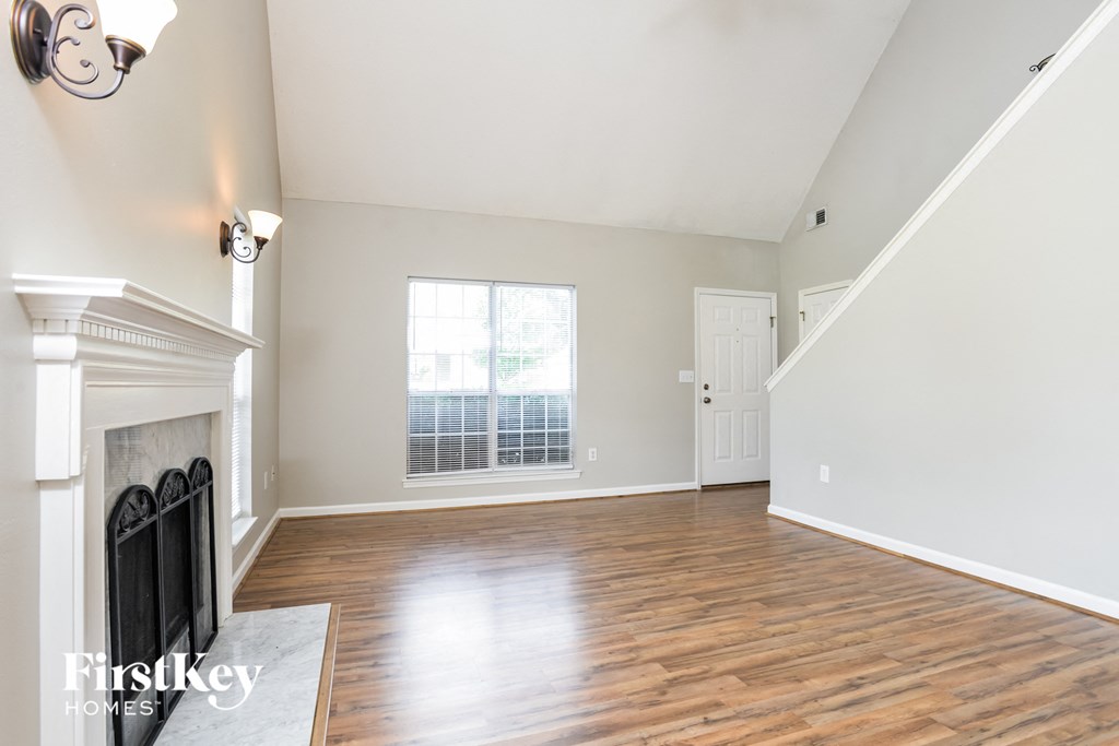 an empty living room with a fireplace and a window
